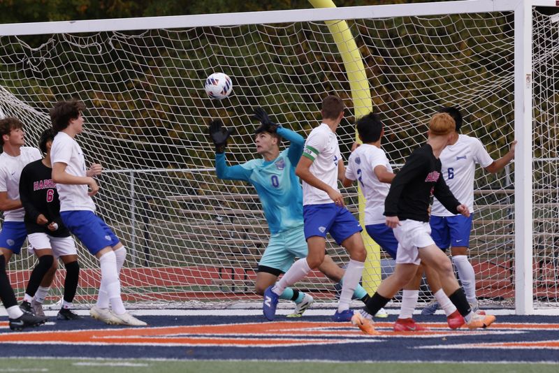 Harrison senior midfielder Aaron Dewell (right) watches his shot sail past Hamilton Southeastern defenders including goalkeeper Riley Bedics (center) on Wednesday, Oct. 15, 2025 during the IHSAA 3A regional semifinals in West Lafayette, Indiana.