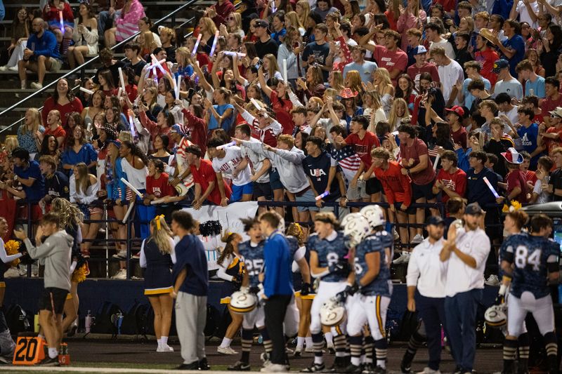 Students cheer after a touchdown as the Memorial Tigers play the Castle Knights at Castle High School in Newburgh, Ind., Friday, Oct. 17, 2025.