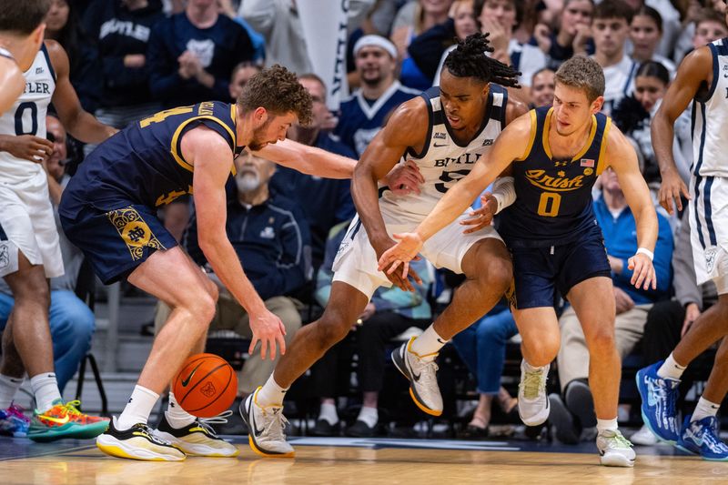Butler Bulldogs forward Michael Ajayi (5) is defended by Notre Dame Fighting Irish forward Matthew MacLellan (34) and guard Brady Stevens (0) during the second half of an NCAA basketball game, Friday, Oct. 17, 2025, at Hinkle Fieldhouse.