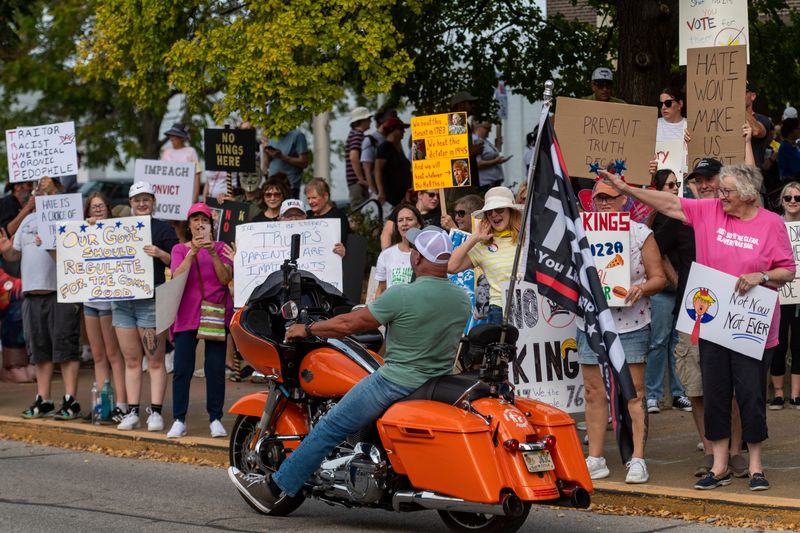 Protesters gather along Martin Luther King Jr. Boulevard during a “No Kings” rally in Downtown Evansville, Ind., Saturday, Oct. 18, 2025.