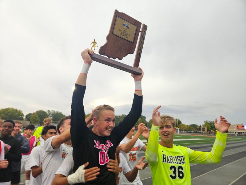 Harrison sophomore goalkeeper Marshall Crowell (center) hoists the IHSAA 3A regional championship trophy after outlasting Homestead 2-2 (4-2 PKs) in Kokomo, Indiana on Saturday, Oct. 18, 2025.