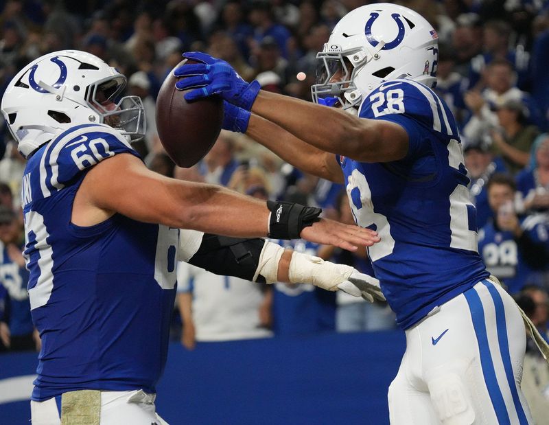 Indianapolis Colts running back Jonathan Taylor (28) celebrates a touchdown with Indianapolis Colts center Tanor Bortolini (60) during the game at Lucas Oil Stadium in Indianapolis.