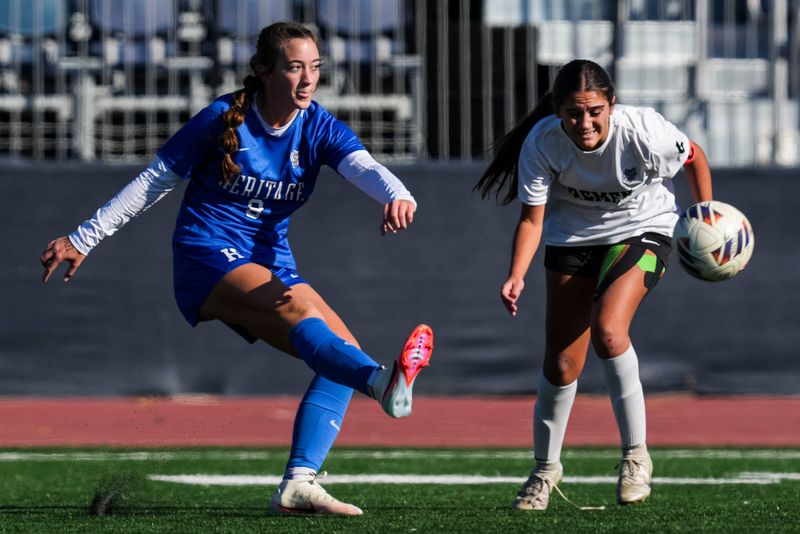 Heritage Christian Eagles midfielder Emma Gast (8) kicks the ball up against Bremen Lions midfielder Taylor Rodriguez (1) on Saturday, Nov. 1, 2025, during the Class 1A girls soccer state championship at the Michael A. Carroll Track and Soccer Stadium at IU Indianapolis.