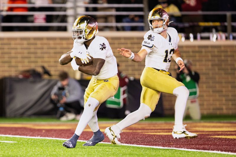 Nov 1, 2025; Chestnut Hill, Massachusetts, USA; Notre Dame Fighting Irish quarterback CJ Carr (13) hands the ball off to running back Jeremiyah Love (4) in the fourth quarter against the Boston College Eagles at Alumni Stadium. Mandatory Credit: Edward Finan-Imagn Images