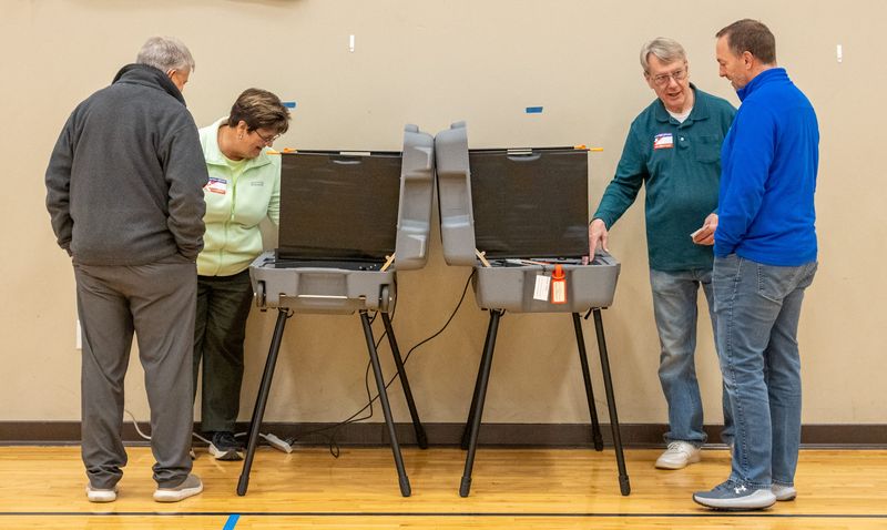 Election day volunteers Steve Hohman (middle right) and 
Barbara Samuels assist Brian Downey (left) and Jason Blackney on Tuesday, Nov. 4, 2025, with the voting process at Our Shepherd Lutheran Church and School in Avon, Indiana.