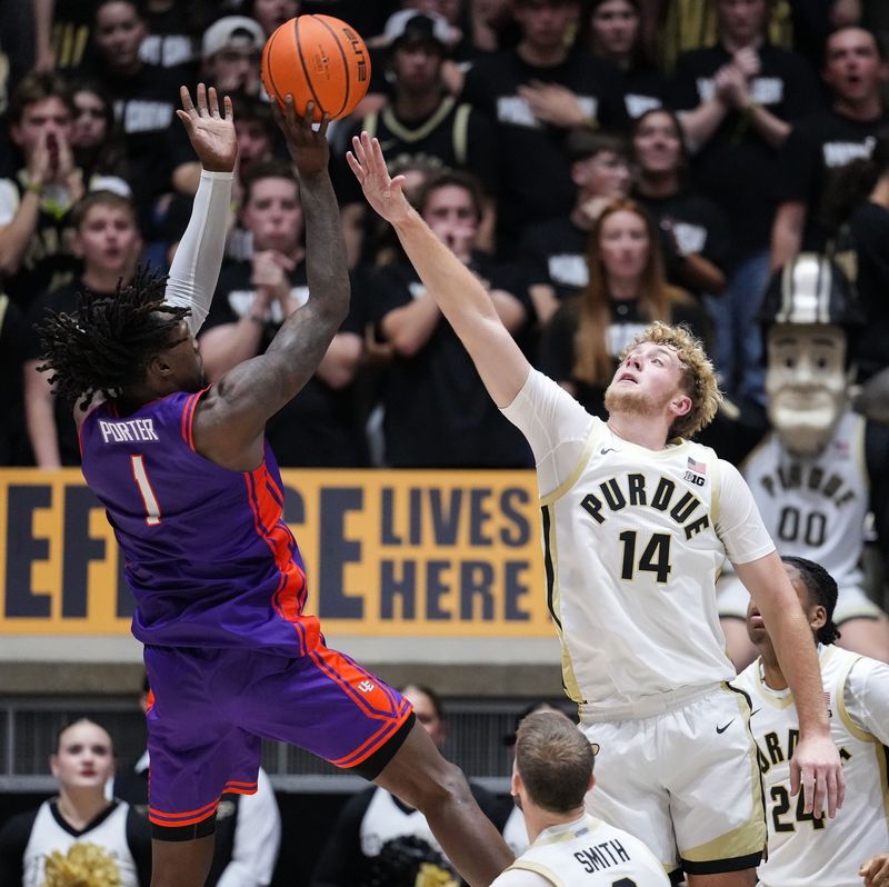Purdue Boilermakers guard Jack Benter (14) attempts to block Evansville Purple Aces guard Keishon Porter (1) on Tuesday, Nov. 4, 2025, during the game at Mackey Arena in West Lafayette. The Purdue Boilermakers defeated the Evansville Purple Aces, 82-51.