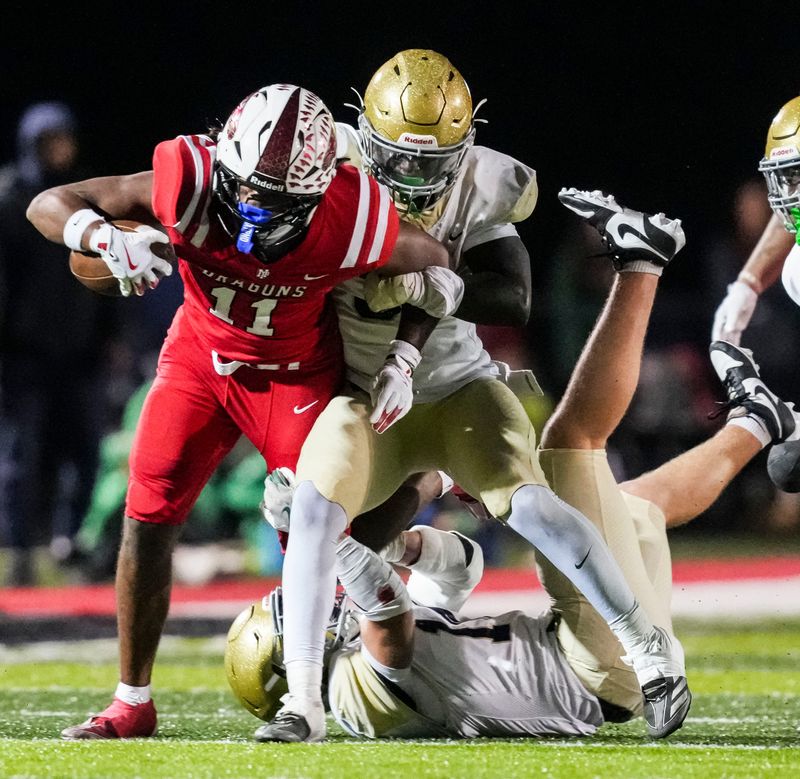 New Palestine Dragons Mason Oglesby (11) carries the ball Friday, Nov. 7, 2025, during a game between the New Palestine Dragons and the Cathedral Fighting Irish at New Palestine High School.