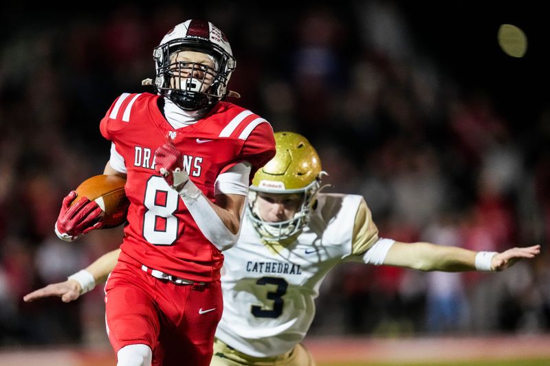 New Palestine Dragons Ryder Gardner (8) runs toward the end zone to score a touchdown as Cathedral Fighting Irish Van Krisiloff (3) attempts to stop Gardner on Friday, Nov. 7, 2025, during a game between the New Palestine Dragons and the Cathedral Fighting Irish at New Palestine High School.