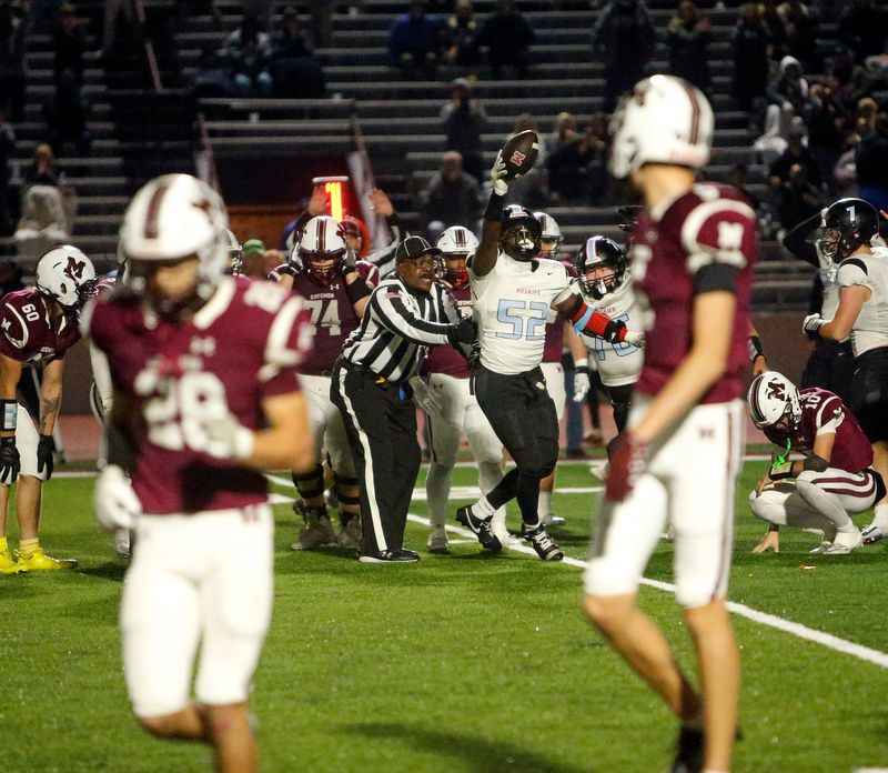 Saint Joseph senior Kobby Addo (52, background) celebrates recovering a Mishawaka fumble during an IHSAA Class 4A football sectional championship game Friday, Nov. 7, 2025, at Mishawaka High School.