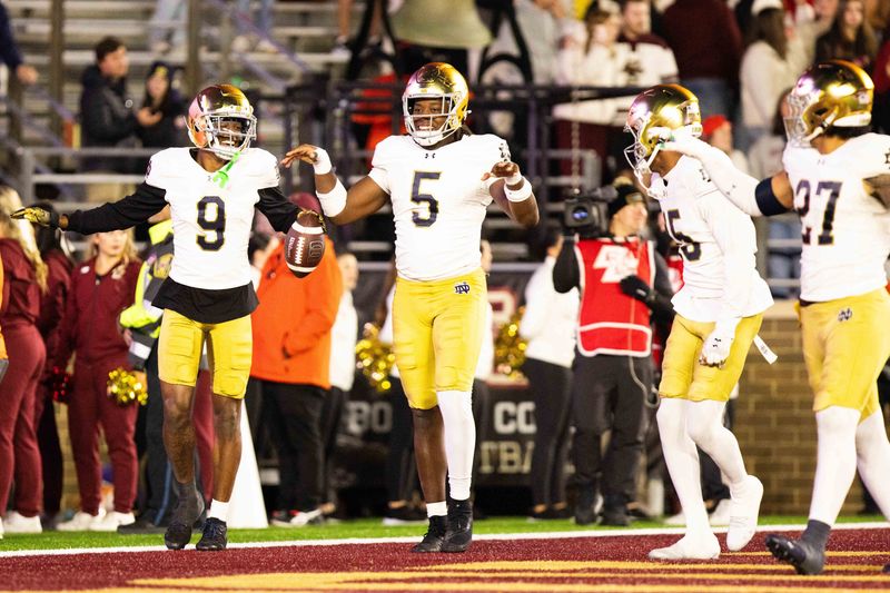 Nov 1, 2025; Chestnut Hill, Massachusetts, USA; Notre Dame safety Tae Johnson (9) and Notre Dame Fighting Irish defensive lineman Boubacar Traore (5) celebrate an interception in the fourth quarter against the Boston College Eagles at Alumni Stadium. Mandatory Credit: Edward Finan-Imagn Images