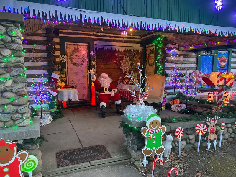 Santa relaxes outside of a decorated park cabin at Eden Springs Park in Benton Harbor.