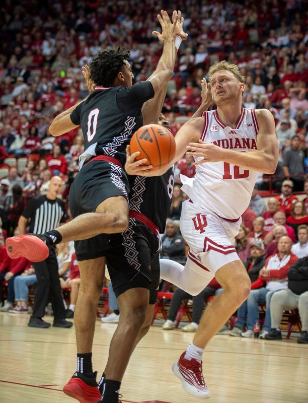 Indiana's Tucker DeVries (12) tries to shoot around Incarnate Word's Esteban Mann (0) during the Indiana versus Incarnate Word men's basketball game at Simon Skjodt Assembly Hall on Sunday, Nov. 16, 2025.