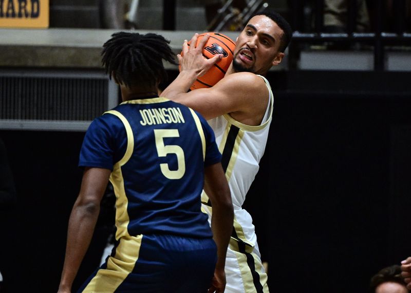 Nov 16, 2025; West Lafayette, Indiana, USA; Purdue Boilermakers forward Trey Kaufman-Renn (4) grabs a rebound in front of Akron Zips guard Tavari Johnson (5) during the first half at Mackey Arena. Mandatory Credit: Marc Lebryk-Imagn Images