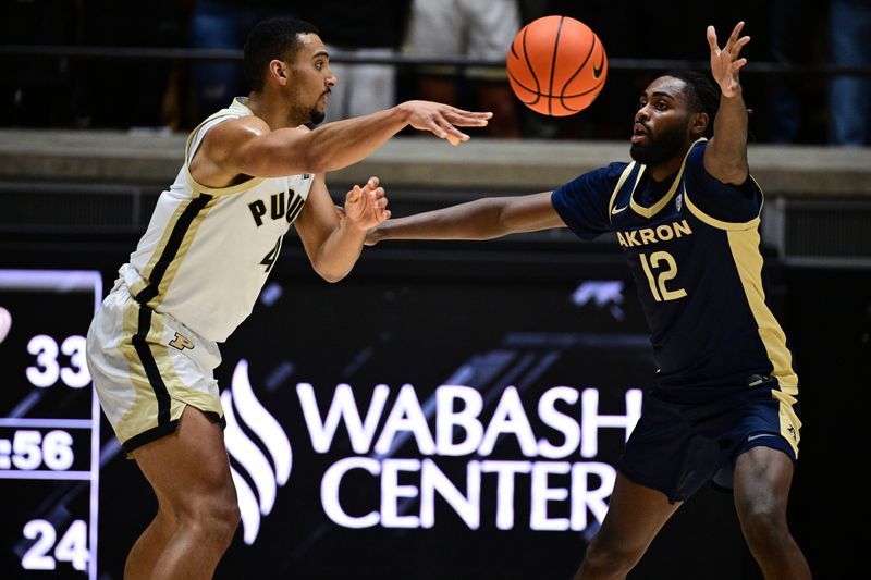 Nov 16, 2025; West Lafayette, Indiana, USA; Purdue Boilermakers forward Trey Kaufman-Renn (4) passes the ball around Akron Zips guard Evan Mahaffey (12) during the first half at Mackey Arena. Mandatory Credit: Marc Lebryk-Imagn Images