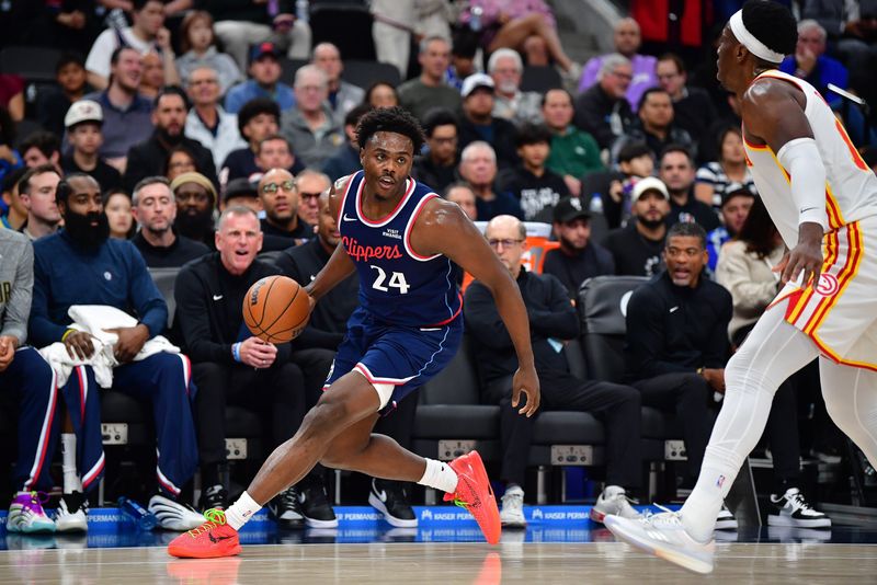 Nov 10, 2025; Inglewood, California, USA; Los Angeles Clippers guard Kobe Brown (24) controls the ball against Atlanta Hawks forward Onyeka Okongwu (17) during the first half at Intuit Dome. Mandatory Credit: Gary A. Vasquez-Imagn Images