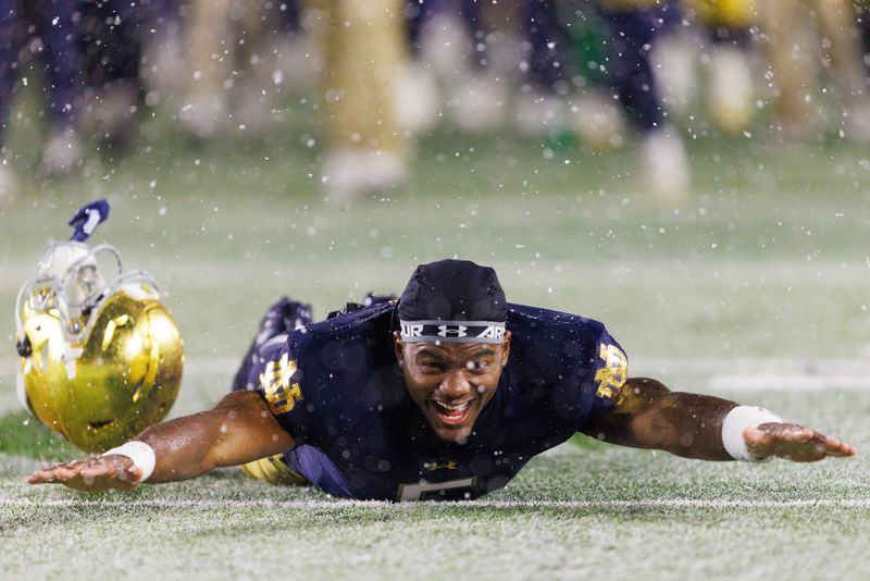Notre Dame wide receiver Cam Williams slides in the snow after winning a NCAA football game 49-10 against Navy at Notre Dame Stadium on Saturday, Nov. 8, 2025, in South Bend.
