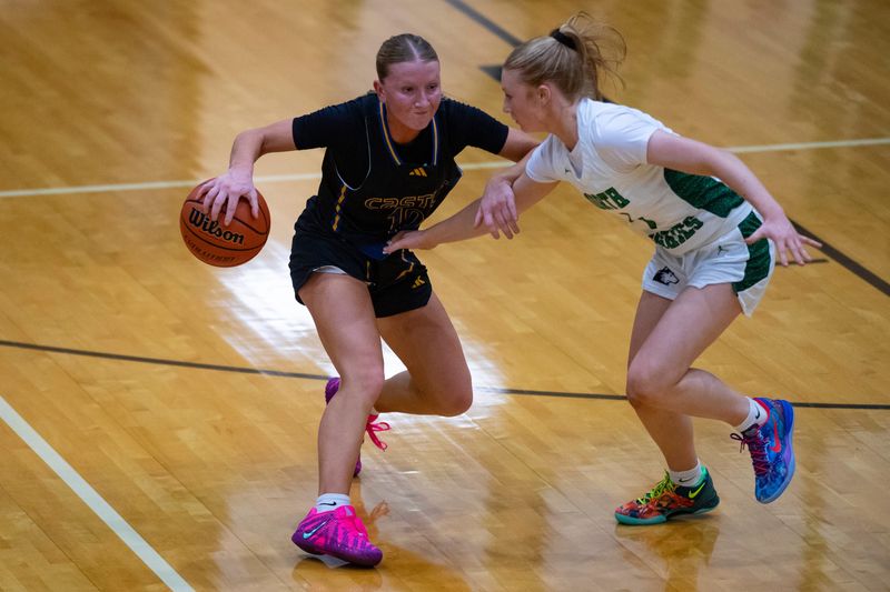 Castle's Paiton Mitchell (10) feels pressure from North's Lexi Scott (1) as the North Lady Huskies host the Castle Lady Knights at North High School in Evansville, Ind., Tuesday, Nov. 25, 2025.