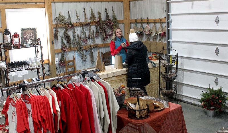 Ashley Ratkovich talks with a customer in the gift shop on Friday, Nov. 28, 2025. She assembles all the wreaths sold in the gift shop at Ratkovich Farm.
