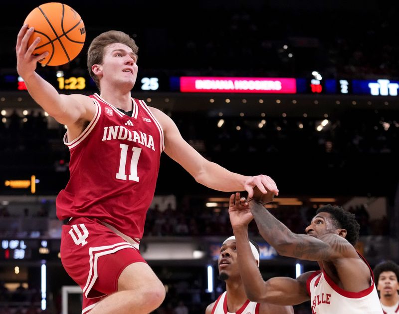 Louisville Cardinals guard Kobe Rodgers (11) defends Indiana Hoosiers forward Trent Sisley (11) as he shoots the ball during a game Saturday, Dec. 6, 2025, at Gainbridge Fieldhouse in Indianapolis. Louisville defeated Indiana 87-78.