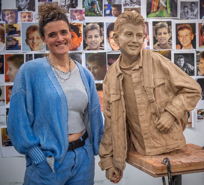 Melanie Pennington holds hands with her sculpture of Ryan White at her studio on the Indiana University campus on Wednesday, Dec. 6, 2025. Once bronzed, the statue will be placed at the Indiana Memorial Union.