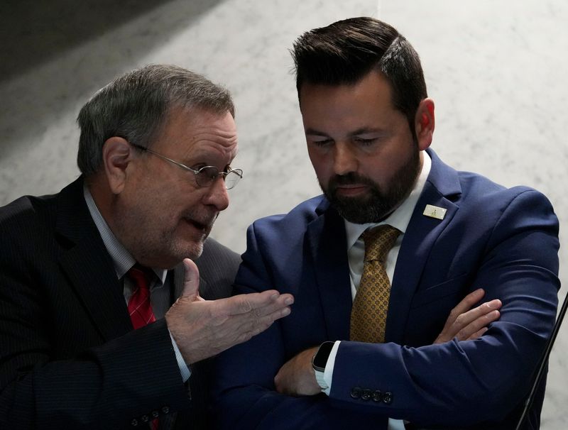 Indiana state Sen. Michael Young, R-Indianapolis, (left) speaks with Lt. Gov. Micah Beckwith as the Senate gathers during mid-cycle session to vote on redistricting Thursday, Dec. 11, 2025, in the Senate Chambers of the Indiana Statehouse in Indianapolis.