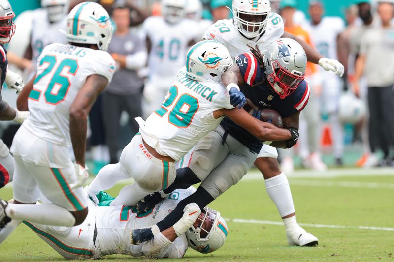 Sep 14, 2025; Miami Gardens, Florida, USA; New England Patriots running back Rhamondre Stevenson (38) carries the football against Miami Dolphins safety Minkah Fitzpatrick (29) during the fourth quarter at Hard Rock Stadium. Mandatory Credit: Sam Navarro-Imagn Images
