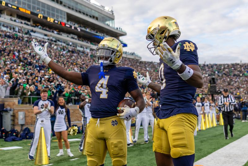 Nov 22, 2025; South Bend, Indiana, USA; Notre Dame Fighting Irish running back Jeremiyah Love (4) celebrates scoring along side Notre Dame Fighting Irish wide receiver Malachi Fields (0) during the first half at Notre Dame Stadium. Mandatory Credit: Michael Caterina-Imagn Images