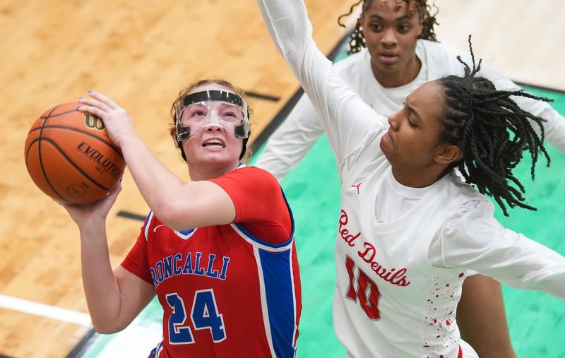 Roncalli Royals Elliot Leffler (24) goes in for a lay-up against Pike Red Devils Malyiah Evans (10) on Monday, Dec. 15, 2025, during the game at Lawrence North High School in Indianapolis. The Pike Red Devils defeated the Roncalli Royals.