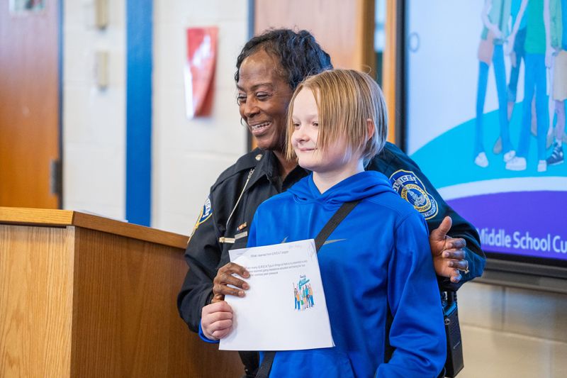 Indianapolis Metropolitan Police Department G.R.E.A.T. officer Marilyn Gurnell gives students awards Tuesday, Dec. 16, 2025, during IMPD’s community engagement and outreach bureau’s G.R.E.A.T. middle school graduation ceremony. G.R.E.A.T. stands for gang resistance education and training.