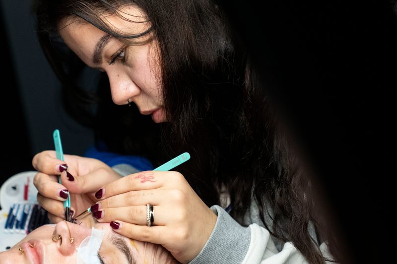 Kaitlyn Golden adds lashes to Bekah Hinkle on Thursday, Dec. 18, 2025, during an appointment at Ink & Ivy Studio in Indianapolis. Golden’s passion for creative lash sets stems through her love of movies, music and pop culture.