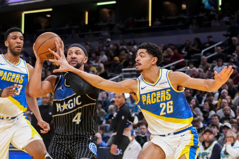 Orlando Magic guard Jalen Suggs (4) drives to the basket against Indiana Pacers center Tony Bradley (13) and Indiana Pacers guard Ben Sheppard (26) on Wednesday, Dec. 31, 2025, during a game at Gainbridge Fieldhouse in Indianapolis.
