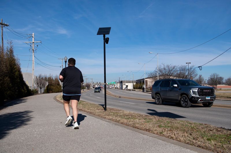 A Flock Safety Falcon camera is seen pointing towards the greenway along Riverside Drive as a runner and vehicle traffic go by in Downtown Evansville, Ind., Wednesday, Jan. 7, 2026.
