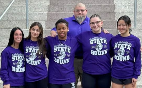 Bloomington South's 2026 girls wrestling state qualifiers pose in front of coach Donnie Hillenburg. From left to right, Mariah Pope, Joslyn Hererra, Samiya Love, Jaclyn Hillenburg and Lila Pierce.
