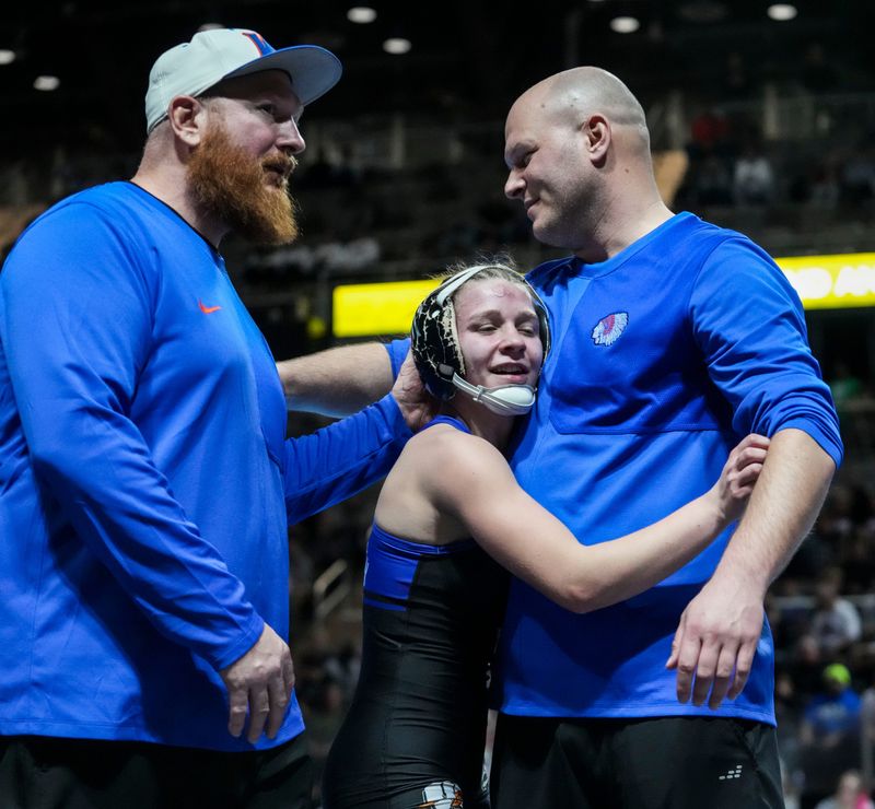 Whiteland Community’s Kaitlynn Fouty celebrates with her coaches Friday, Jan. 16, 2026, during the championship match at the 2026 IHSAA girls wrestling state finals at Corteva Coliseum at the Indiana State Fairgrounds in Indianapolis. Fouty won by decision, 5-3.