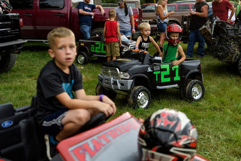 Declan Tooley, 6, from front left, Brigston Baum, 2, and Trace Spurgeon, 5, wait for the lightening and thunder to pass so they can compete in the Gibson County Fair's Powerwheels Demo Derby at the fairgrounds in Princeton, Ind., Saturday, July 14, 2018. The stormy weather cleared up enough for them to compete and be able to watch the demo derby later that night.