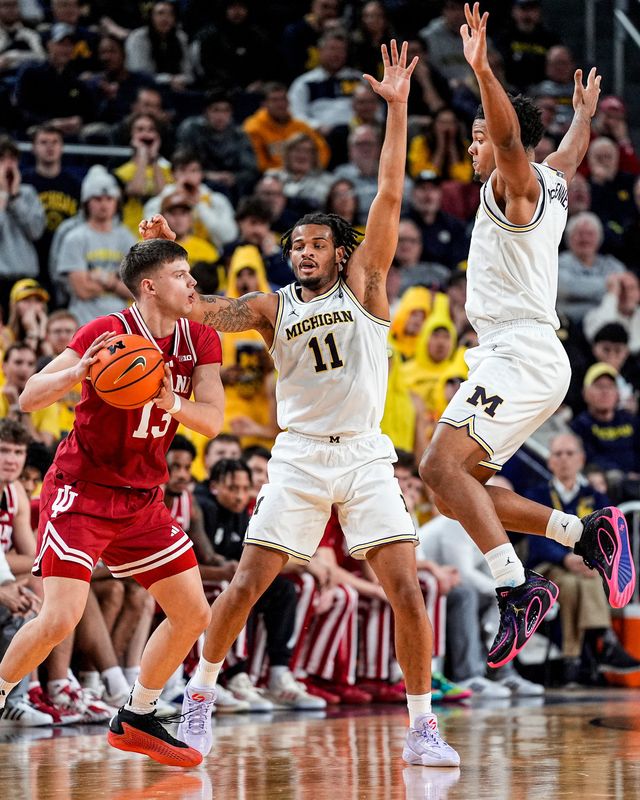 Michigan guard Roddy Gayle Jr. (11) and guard Trey McKenney (1) defend Indiana guard Aleksa Ristic (13) during the second half at Crisler Center in Ann Arbor on Tuesday, Jan. 20, 2026.