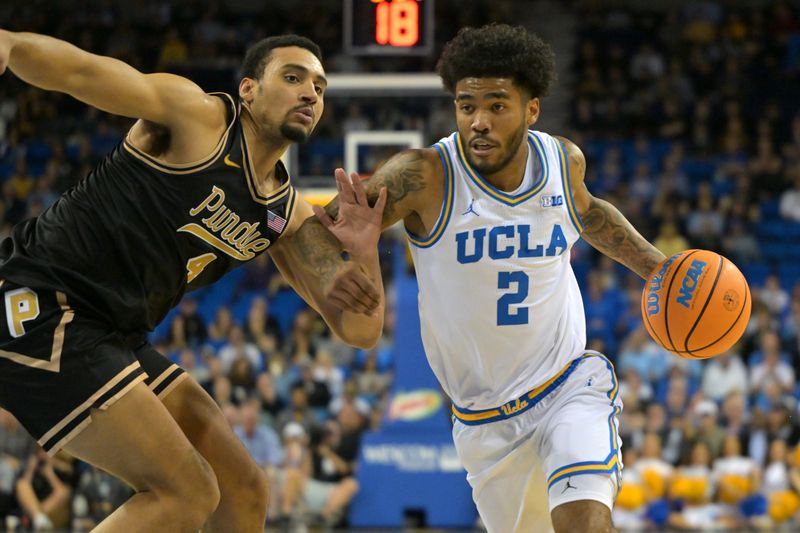 Jan 20, 2026; Los Angeles, California, USA; UCLA Bruins guard Donovan Dent (2) drives past Purdue Boilermakers forward Trey Kaufman-Renn (4) in the first half at Pauley Pavilion presented by Wescom Financial. Mandatory Credit: Jayne Kamin-Oncea-Imagn Images