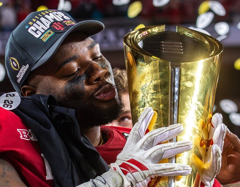 Indiana's Tyrique Tucker (95) lifts the trophy on the podium after the College Football Playoff National Championship college football game at Hard Rock Stadium in Miami Gardens on Monday, Jan. 19, 2026.
