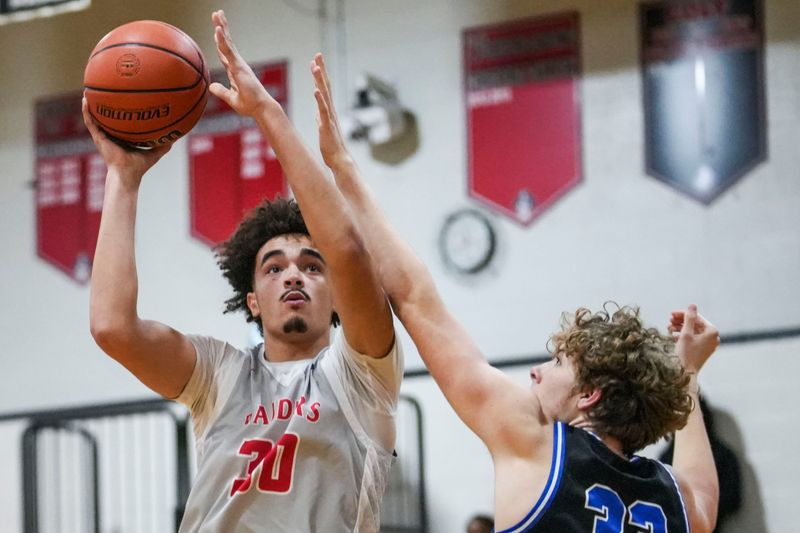 Cardinal Ritter Raiders Devin Bolden (30) goes up for a basket against Heritage Christian Eagles Logan Peters (33) on Thursday, Jan. 22, 2026, during a game between the Cardinal Ritter Raiders and the Heritage Christian Eagles at Cardinal Ritter High School in Indianapolis. The Raiders won in overtime, 68-67.