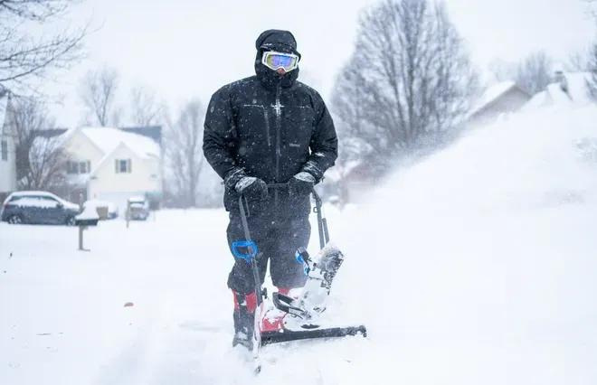 Mark Bruce uses a snowblower Sunday, Jan. 25, 2026, along the street in front of his Avon, Indiana, home.