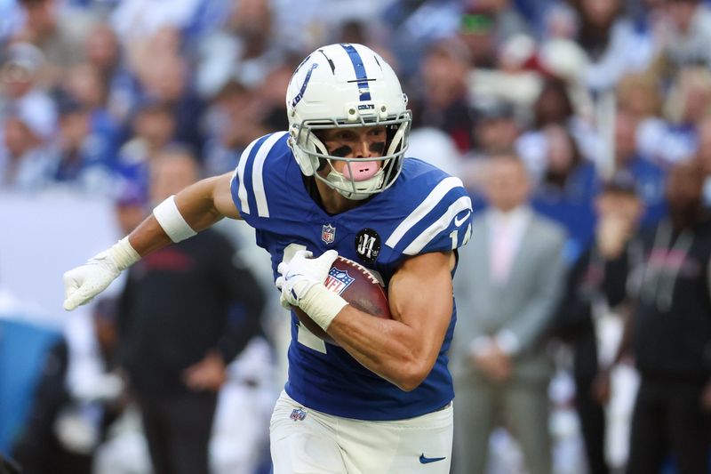 Oct 12, 2025; Indianapolis, Indiana, USA; Indianapolis Colts wide receiver Alec Pierce (14) carries the ball against the Arizona Cardinals during the fourth quarter of the game at Lucas Oil Stadium. Mandatory Credit: Trevor Ruszkowski-Imagn Images