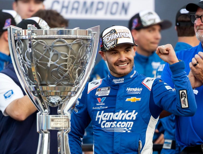 Nov 2, 2025; Avondale, Arizona, USA; NASCAR Cup Series driver Kyle Larson (5) celebrates with the Bill France Cup trophy after clinching the 2025 NASCAR Cup Series Championship following the NASCAR Championship race at Phoenix Raceway. Mandatory Credit: Mark J. Rebilas-Imagn Images
