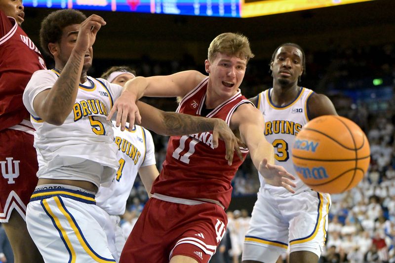 Jan 31, 2026; Los Angeles, California, USA; UCLA Bruins guard Brandon Williams (5) and Indiana Hoosiers forward Trent Sisley (11) reach for a ball going out of bounds, that was awarded to Indiana, in the second overtime period at Pauley Pavilion presented by Wescom Financial. Mandatory Credit: Jayne Kamin-Oncea-Imagn Images