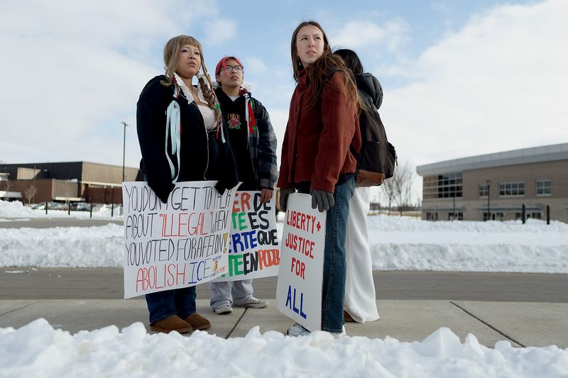 From left, Zarielis Zavas, Axel Castandeda and Sopia Bittinger watch as the last of the protesters trickled back toward the school on Wednesday, Feb. 4, 2026, at Lafayette Jefferson High School in Lafayette, Ind. Zavas and Bittinger run the instagram account @jhs.against.ice and organized the walkout.
