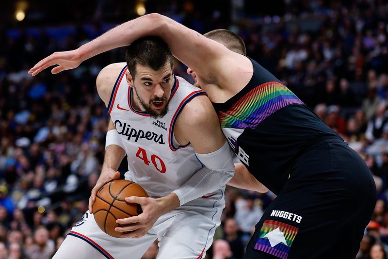 Clippers center Ivica Zubac (40) drives into Nuggets center Nikola Jokic (15) in the first quarter at Ball Arena in Denver on Jan. 30, 2026.