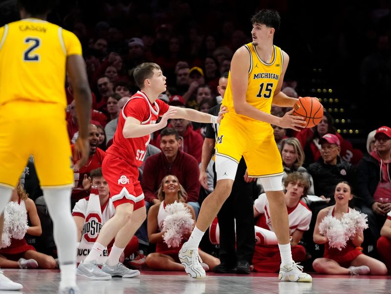 Ohio State Buckeyes guard Gabe Cupps (4) guards Michigan Wolverines center Aday Mara (15) during the NCAA men's basketball game at the Schottenstein Center in Columbus on Feb. 8, 2026.