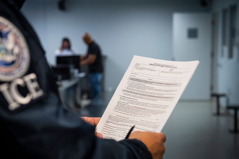 An undated photo published by U.S. Immigration and Customs Enforcement shows an officer at a government detention facility holding an immigration detainer form.