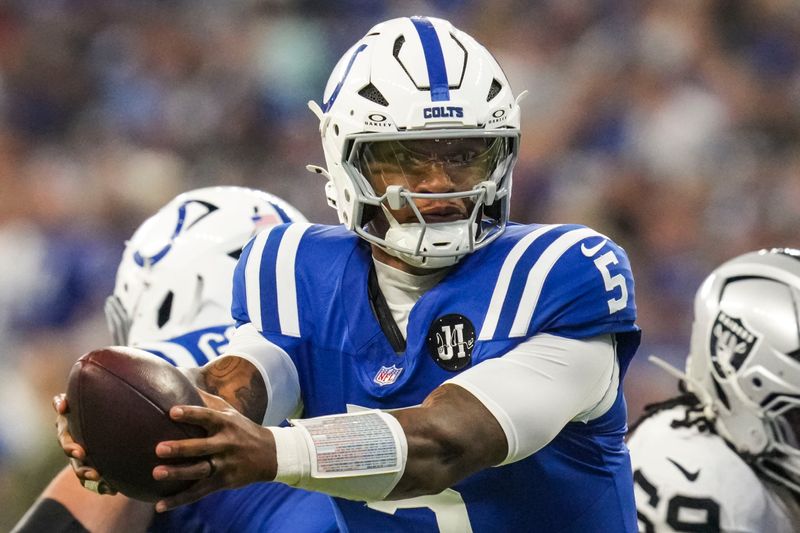 Indianapolis Colts quarterback Anthony Richardson (5) hands off the ball Sunday, Oct. 5, 2025, during a game against the Las Vegas Raiders at Lucas Oil Stadium in Indianapolis. The Indianapolis Colts defeated the Las Vegas Raiders, 40-6.