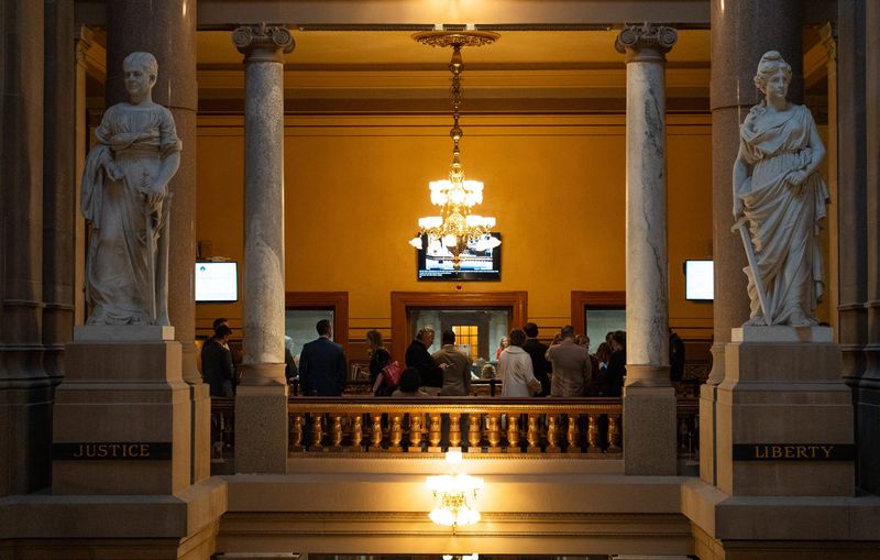 People stand and watch Friday, Feb. 27, 2026, from outside the Senate Chamber during the final day of the legislative session at the Indiana Statehouse in Indianapolis.