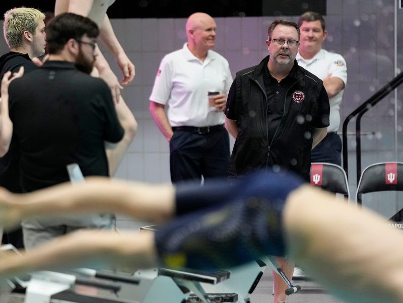 Fishers' head coach Joe Keller coaches from the pool deck Saturday, Feb. 28, 2026, during the IHSAA boys swimming state finals at the IU Natatorium in Indianapolis.